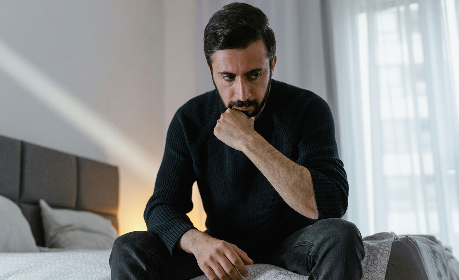 An introvert overthinking something on his bed