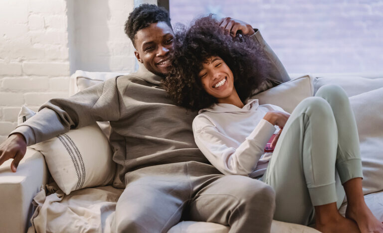 An introvert-extrovert couple relax on the couch