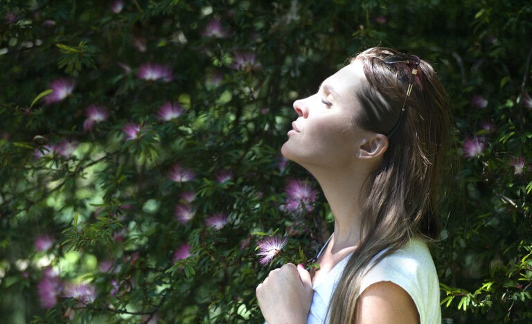 An anxious introvert practices a breathing technique and takes time to smell some flowers