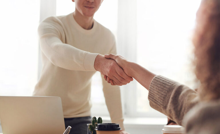 An employee shakes an introvert employee’s hand