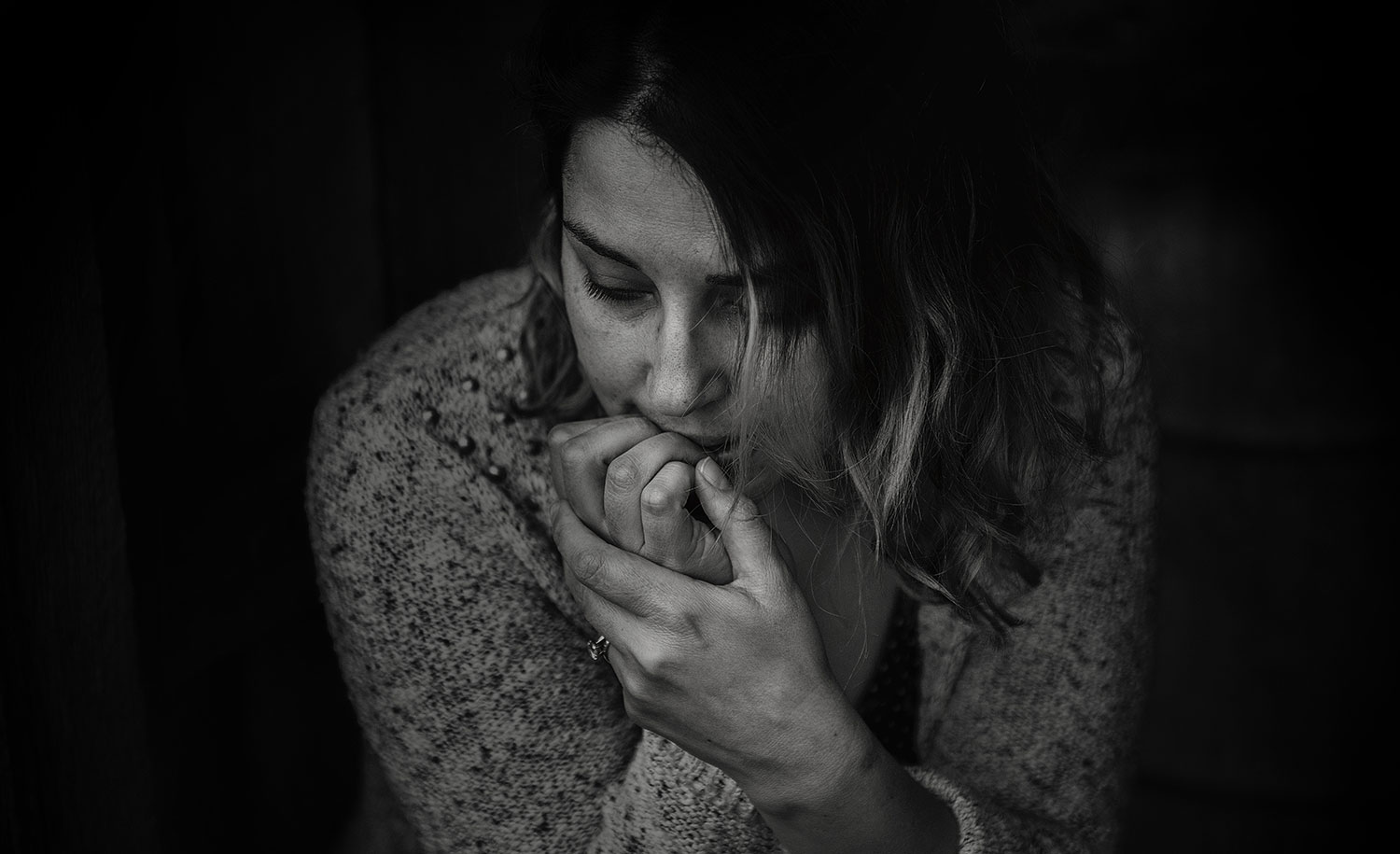 A woman looks down, worried
