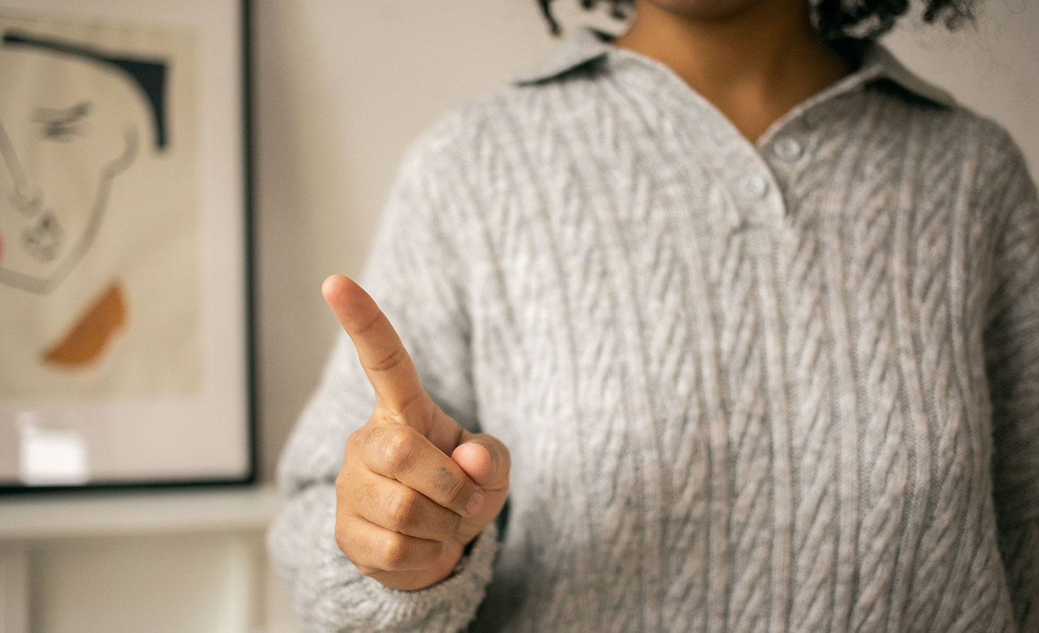 An introvert waves her finger as if to say “no”