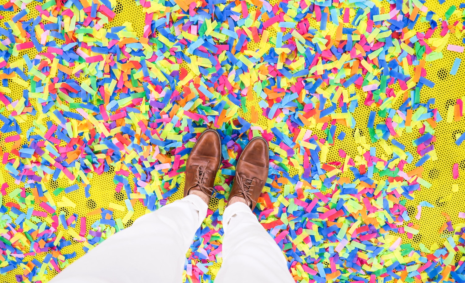 An introvert stands on confetti from a party.