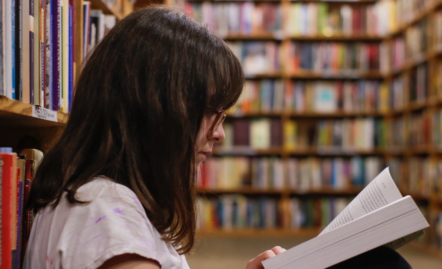 a quiet introverted student reads in the library