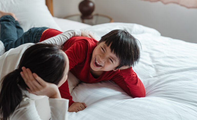 An introverted mother on the bed with her extroverted child