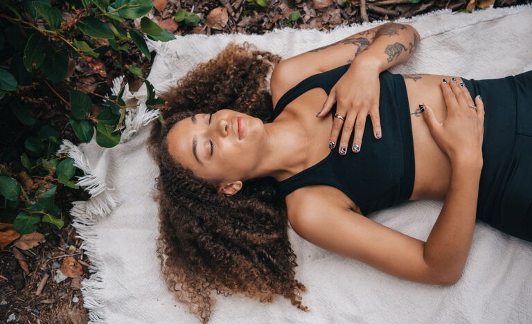 A highly sensitive, introverted parent lies down on a mat and takes some me time to recharge